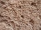 Rough brown pitted eroded limestone surface texture background