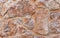 Rough brown stone wall close up, seamless textured background.