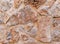 Rough brown stone wall close up, seamless textured background.