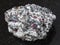 Rough corundum crystals in gneiss stone on dark