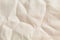 Rough crumpled light sand linen background texture close up frontal view.