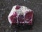 rough crystal of red garnet gemstone on dark