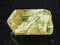 rough crystal of yellow apatite gemstone on dark