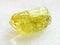 Rough crystal of yellow Apatite gemstone on white