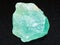 rough green Calcite stone on dark background