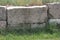 Rough-hewn drystone blocks used in a retaining wall with moss growing in the cracks between them