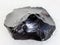 rough obsidian (volcanic glass) crystal on white