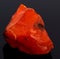 Rough red carnelian rock isolated on black