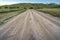 Rough road on a scenic hill landscape blanketed with lush greenery and trees