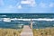 Rough sea with waves in autumn or winter, wooden path