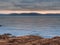 Rough stone coast of Galway bay Ireland at blue hour. Burren mountains in the background. Calm and peaceful mood. Irish landscape