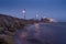 Rough stone coast of Salthill, Galway city Ireland. Blue hour. Town illumination reflects in calm water of the ocean. Calm and