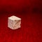 Rough stone cube isolated on blurred red background