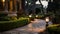 rough stone path illuminated by iron garden lights surrounded by hedge.