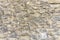 Rough surface of random pattern rastic of brown and light yellow color natural free form sand stone cladding on the concrete wall