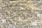 Rough surface of random pattern rastic of brown and light yellow color natural free form sand stone cladding on the concrete wall