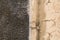 Rough wall texture of 2 sections: uneven dark gray and weathered beige-painted surface