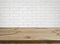 Rough wooden texture table over defocused white brick wall background