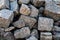 Roughly heaped granite stones, outdoor weathered material, large building blocks. Close-up
