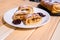 Roulade with apples, strudel on a white and black and white plate on a wooden background