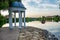 Round arbor in the classical style on the banks of the pond in the park