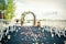 Round arch with white flowers on pier with white chairs around. Check-out on the river or lake. Wedding registration. Wedding