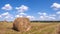 Round bale of straw in the meadow. Agriculture field with hay bales. Rural nature in the farm land with straw on the meadow. Wheat