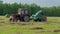 Round baler discharge round fresh hay bale during agricultural harvesting in field