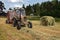 Round baler dumping a freshly rolled hay bale.