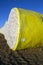 Round bales of harvested cotton wrapped in yellow plastic