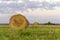 Round bales of hay on a beveled meadow