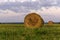 Round bales of hay on a beveled meadow