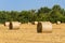 Round bales of straw in endless field after harvesting wheat. Blurred background. Selective focus. Close-up. Straw bales