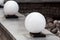 Round ball street lighting on granite stone parapet.