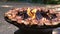 Round barbecue grill with open fire inside. Cooking chicken or turkey for a summer picnic.