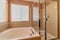 Round bathtub and shower stall with glass wall and door in residential bathroom