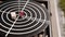 Round black disc of the balance board game hangs on chain and sways.