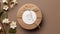 a round blank sticker mockup placed on a kraft paper gift bag adorned with delicate white flowers, the adhesive thank