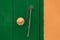 Round brass knob on green doors near orange wall