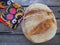 round bread top view. Delicious fresh cornbread with sprinkles on an old wooden table and a beautiful traditional towel