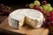 Round brie cheese with notch close-up, yellow camembert on wooden board with green grapes. Italian food. Dairy product. Still life