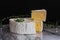 Round Brie cheese with a section cut out on a marble tray. Fresh Camembert cheese. on darck background. Selective focus