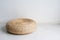 Round brown wicker chair in vintage style setting on concrete floor in white room.