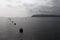 Round buoys of a marine farm on the water surface of the sea against a cloudy sky