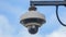 Round CCTV camera against blue sky