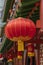 Round Chinese lantern in red on the facade of a traditional house