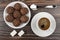 Round chocolate cakes in saucer, coffee, lumpy sugar and spoon