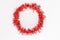 Round circle of bright red tinsel on white background. Christmas decorations. New year concept