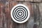 Round circular black and white target with numbers hanging on a wooden wall