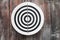 Round circular black and white target with numbers hanging on a wooden wall